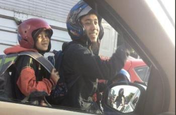 Bapak dan anak ini tetap bercanda meski terjebak macet. (Twitter/ Lexandroi)